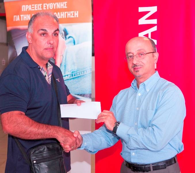 Ο τυχερός τα κλήρωσης για την ασφάλιση αυτοκινήτου κ. Δημήτρης Μαύρος παραλαμβάνει το ασφαλιστήριο από τον Γιάννη Ρούντο, Διευθυντή Δημοσίων Σχέσεων & ΕΚΕ Ομίλου INTERAMERICAN